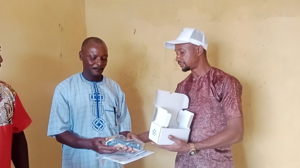 Hon. Ndubuisi Paschal handing over one of the POS machines to one of the executive members